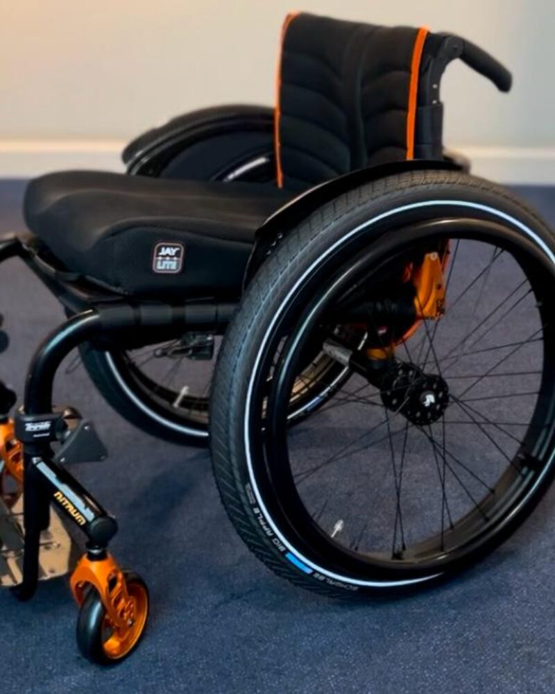 black and orange quickie nitrum wheelchair side view