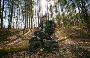 man in woods on a Quantum Rehab Outback off road powerchair