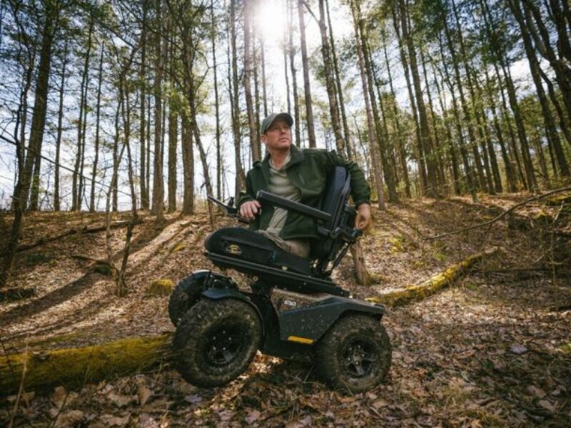 man in woods on a Quantum Rehab Outback off road powerchair