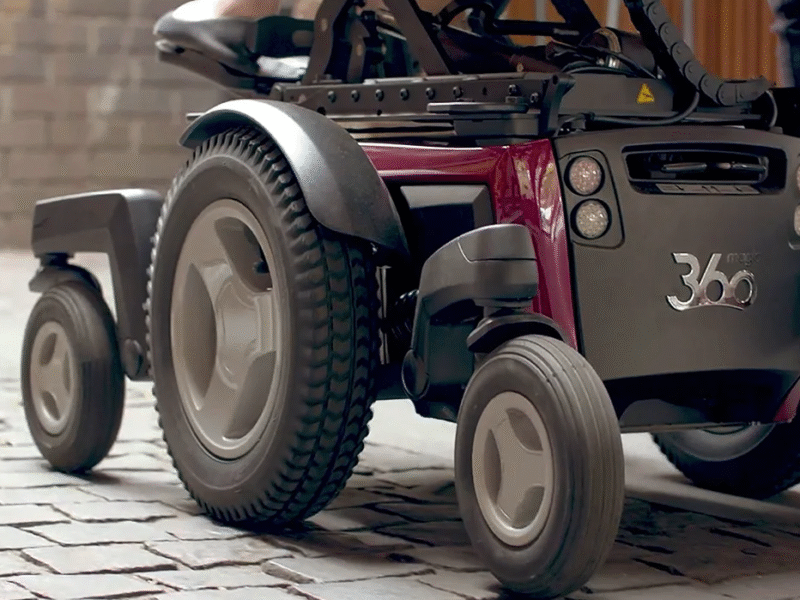 close u of the wheels on a magic 360 power chair in purple
