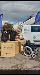 Staff from arb mobility stood next to a van with wheelchairs next to them